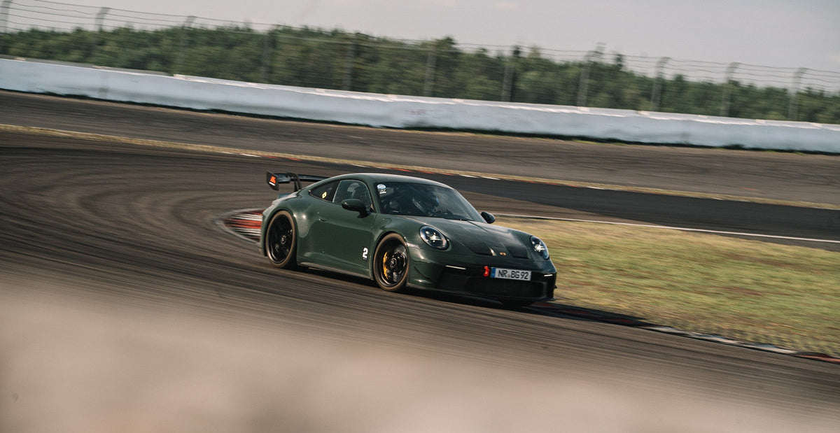 Dark green street-legal Porsche 911 GT3 at the Bilster Berg, panning shot