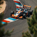 Orange-weißer Formel-4 Wagen mit Startnummer 17 aus der Vogelperspektive über die bunten Curbs des Automotodrom Brno bei einem Testtag.