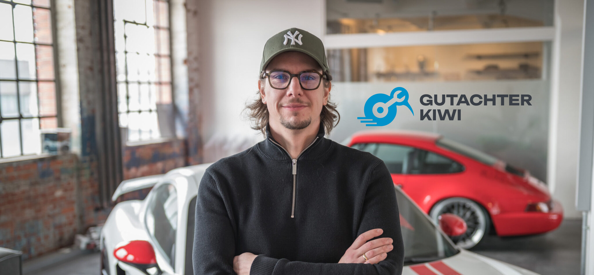 Gutachter Kiwi Portrait vor einem Porsche Cayman GT4 Sondermodell Sports Cup und einem roten Porsche 964 RS mit BBS Felgen.