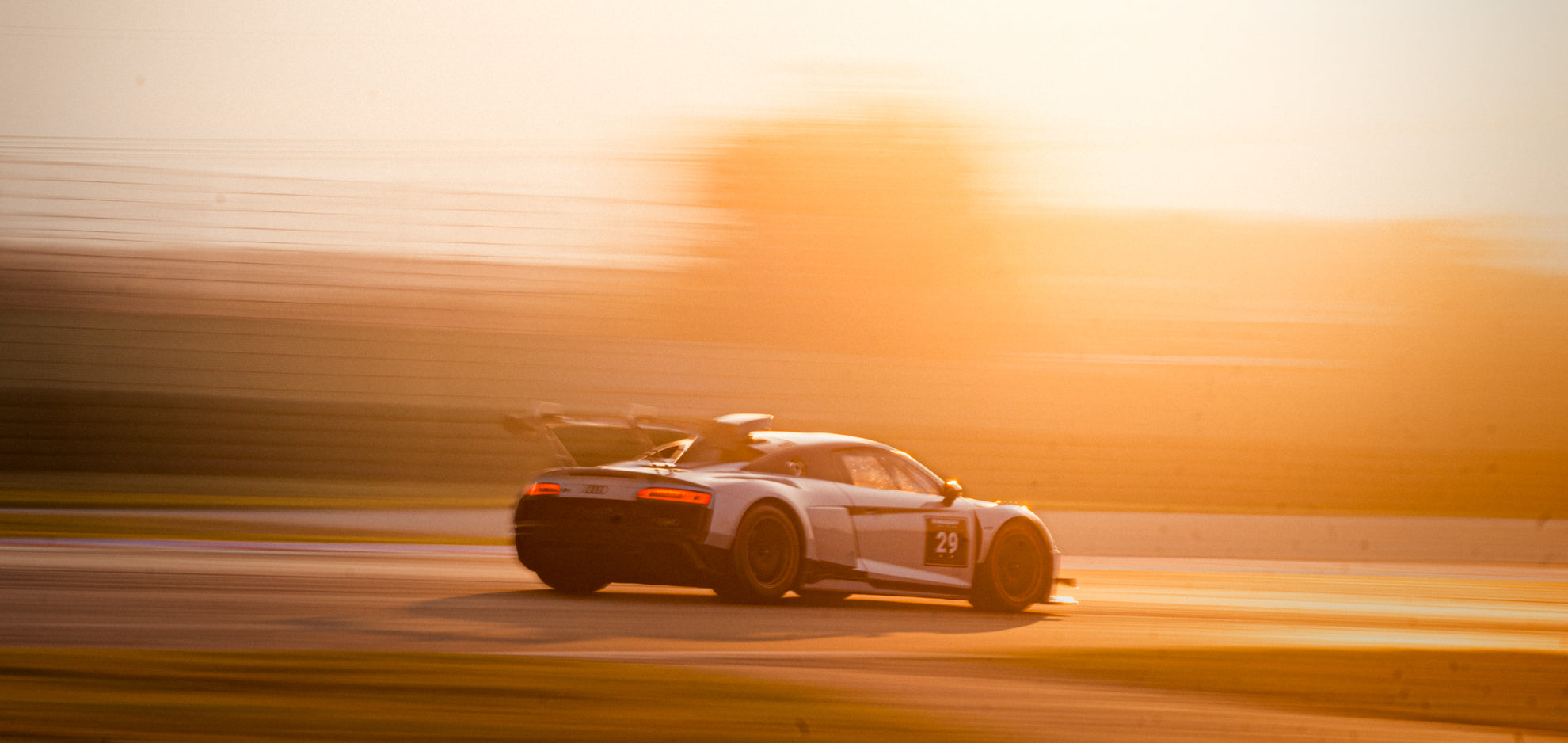 Sonnenuntergang auf einer Rennstrecke mit einem weißen Audi R8 GT2 