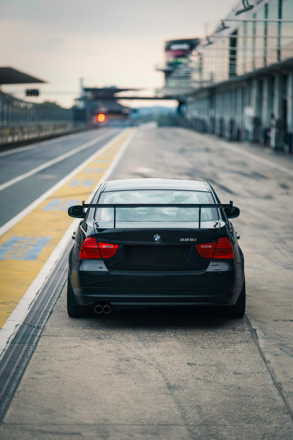 BMW 330i E90 Mietfahrzeug von TWENTYSEVEN Trackdays von hinten mit einstellbarem Heckflügel und Überrollkäfig