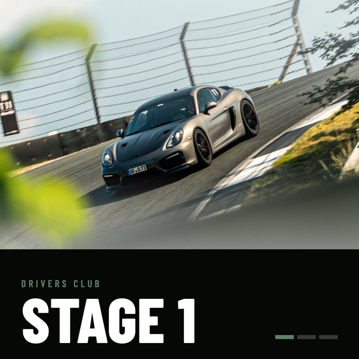 Drivers Club Stage 1: grauer Porsche Cayman mit schwarzer Motorhaube und Startnummer 71 in einer Kurve auf der Rennstrecke