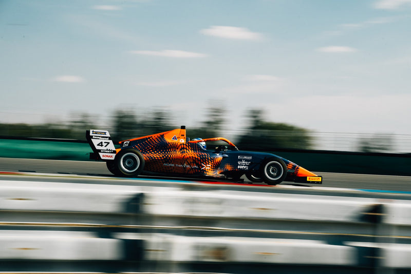 Orange-blauer Formelrennwagen mit Startnummer 47 in voller Fahrt bei einem Formel-Testtag.