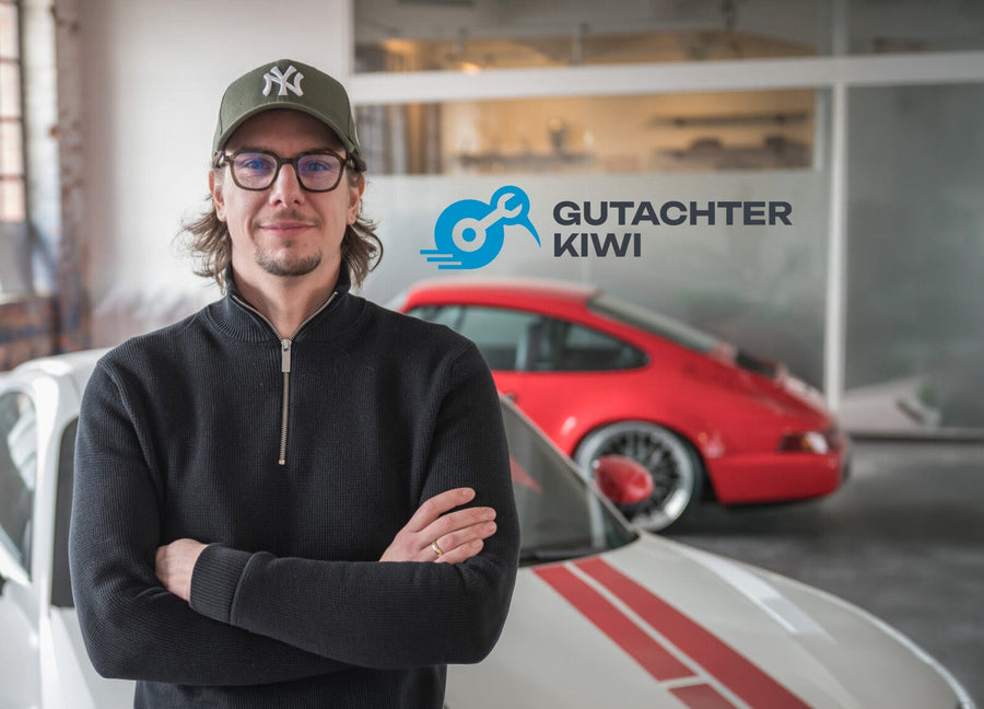 Matthias Kiwitt of Gutachter Kiwi in his workshop, with the company logo in the background.