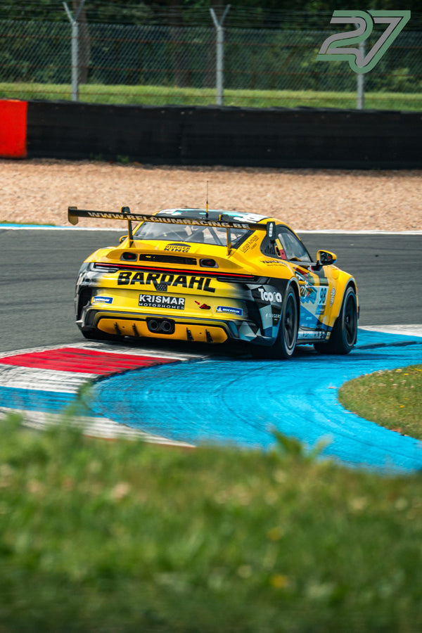 Gelber Porsche 911 Cup-Rennwagen füllt das Bild beim Herausbeschleunigen aus der Kurve