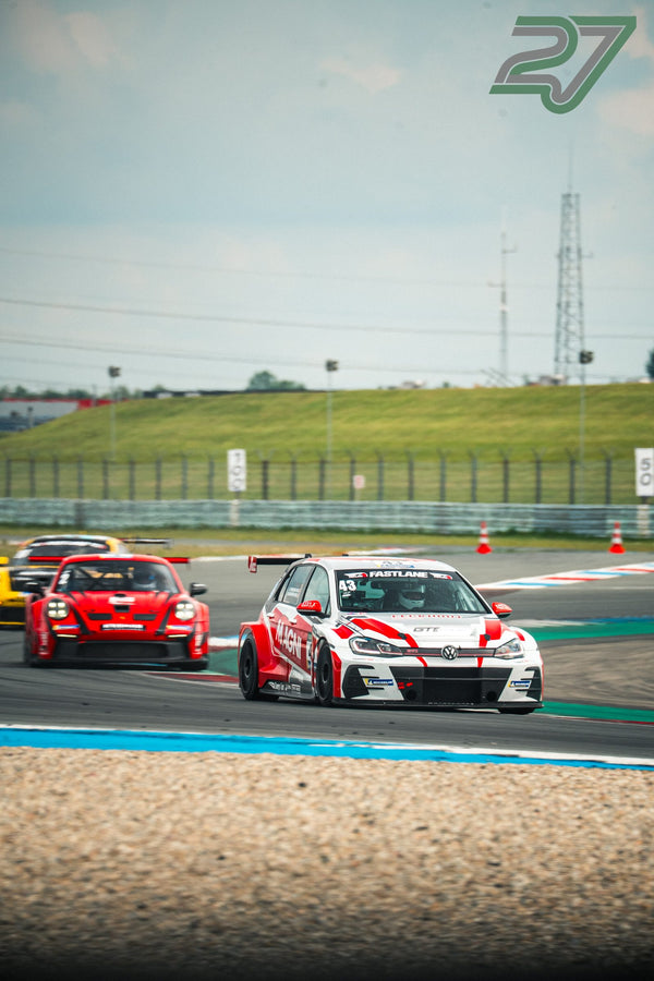 Rot-weißer VW Golf GTI TCR zieht vor einem roten Porsche 911 durch die Kurve auf dem TT Circuit