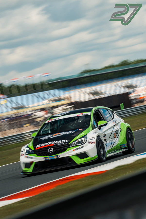 Weiß-grüner Opel Astra TCR nähert sich schräg von vorn unter dicht bewölktem Himmel über Assen