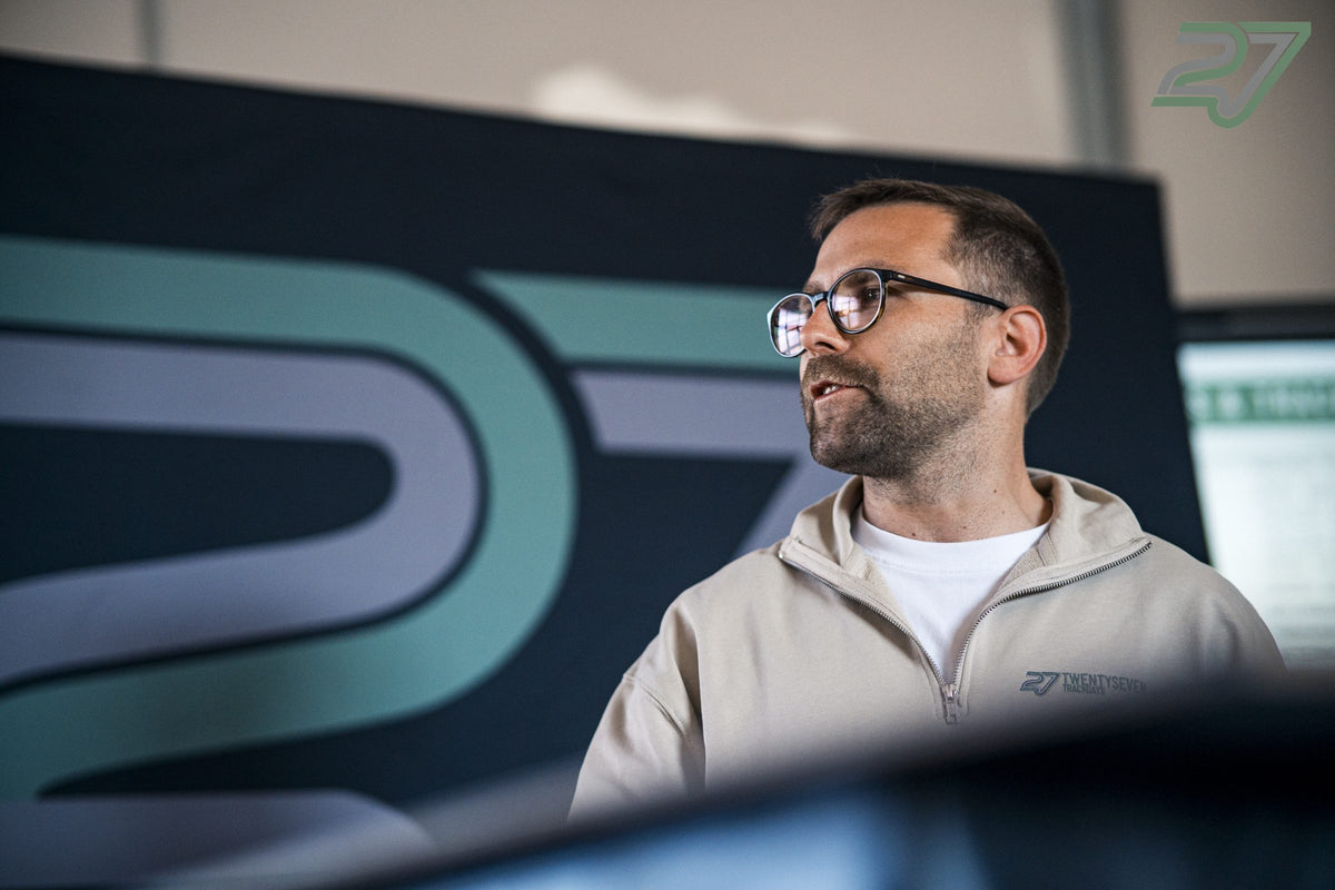 Briefing in the paddock in front of the large 27 logo