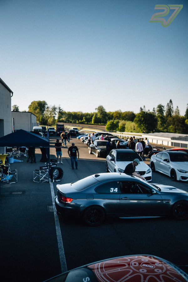 Geparkte Sportwagen und Zelte prägen das Fahrerlager am Bilster Berg in der Abendsonne