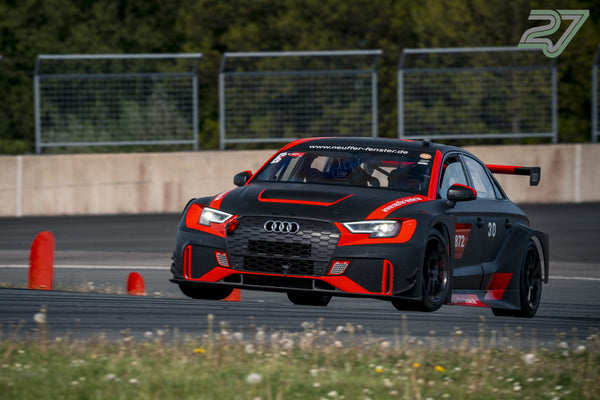 Schwarz-roter Audi RS3 fährt eng an orangen Pylonen vorbei, Startnummer 30 gut sichtbar