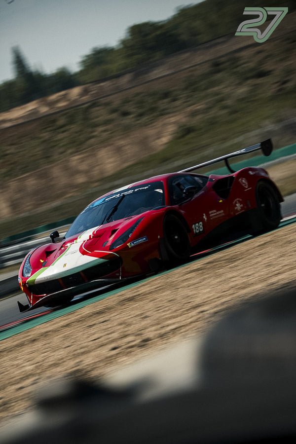 Roter Ferrari-GT3-Rennwagen mit Startnummer 188 in italienischer Flaggenlackierung bremst tief vor der Kurve