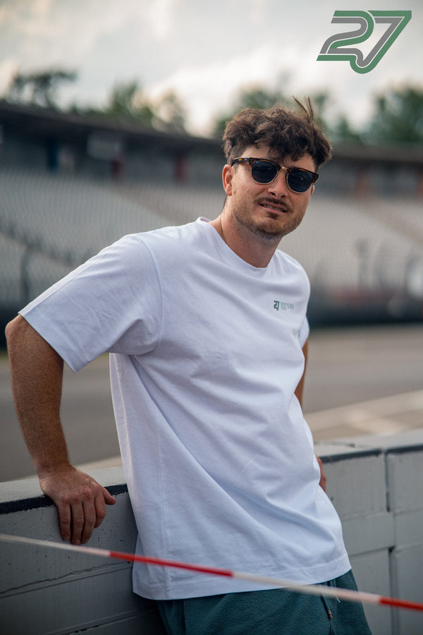Mann mit Sonnenbrille lehnt lässig an der Streckenbegrenzung vor der Tribüne des Hockenheimrings