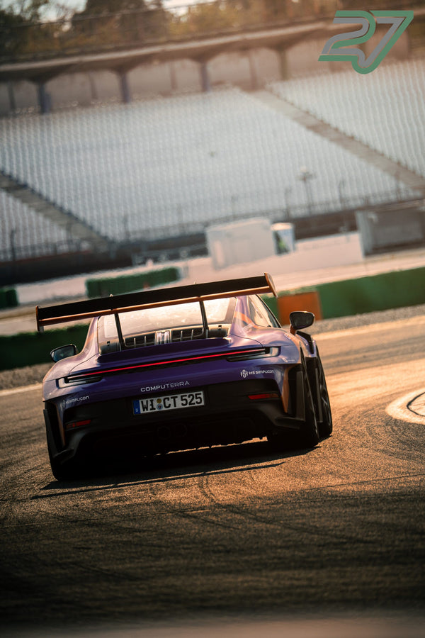 Violetter Porsche mit großem Heckflügel fährt im Gegenlicht der tiefstehenden Sonne