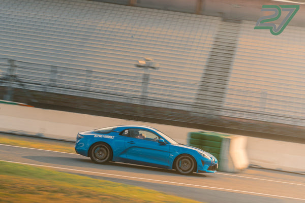Blauer Alpine A110 mit Startnummer 5 fährt in Seitenansicht durch die Kurve, Fahrer sichtbar