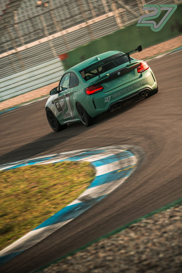 Mintgrüner BMW M2 mit Twentyseven-Beschriftung neigt sich im Kurvenscheitel bei goldenem Licht