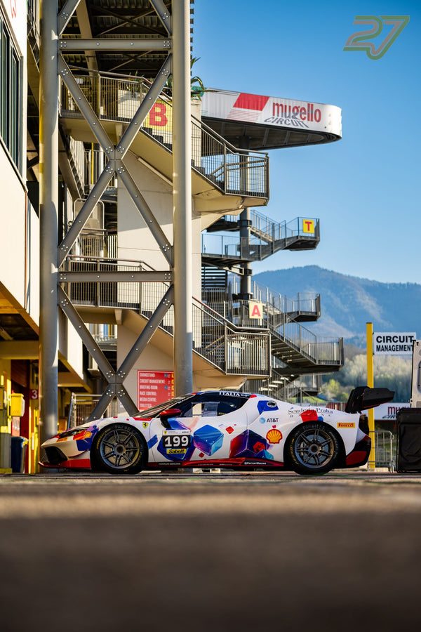 Weißer Ferrari Challenge mit Startnummer 199 in der Boxengasse, dahinter der Mugello-Boxenturm