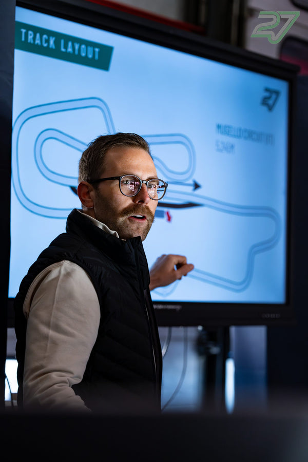Ein Referent mit Brille deutet auf den Bildschirm mit dem Streckenlayout des Mugello