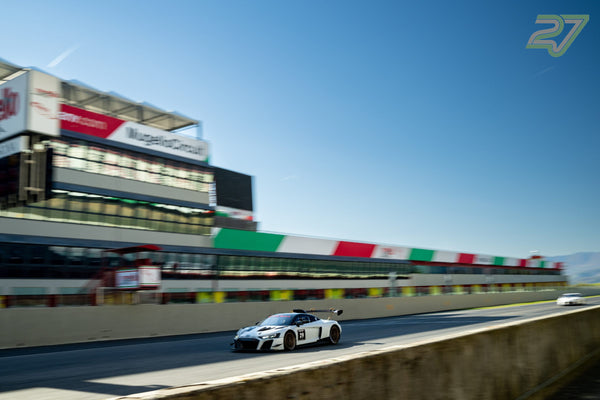 Weißer Audi R8 LMS mit Startnummer 29 im Mitzieher vor der langen Mugello-Haupttribüne