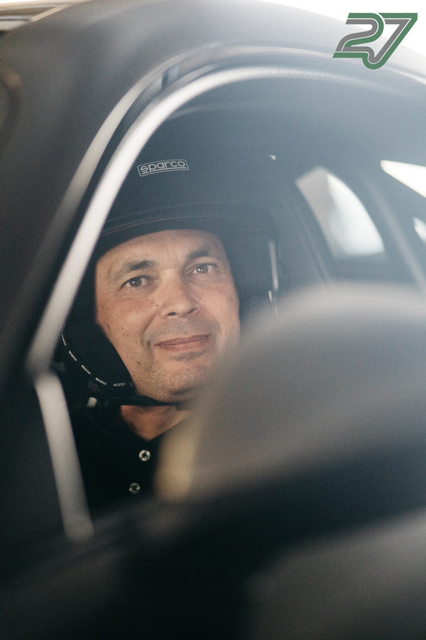 Porträt eines lächelnden Fahrers mit Helm hinter der Fensterscheibe im Cockpit
