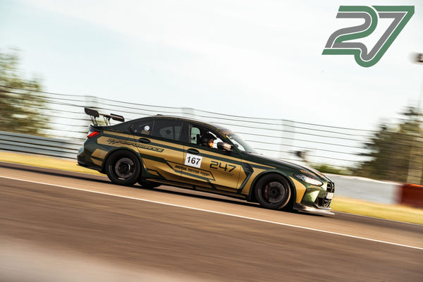 Grün-goldener BMW M3 mit auffälliger Folierung fährt im Seitenprofil durch eine schnelle Passage