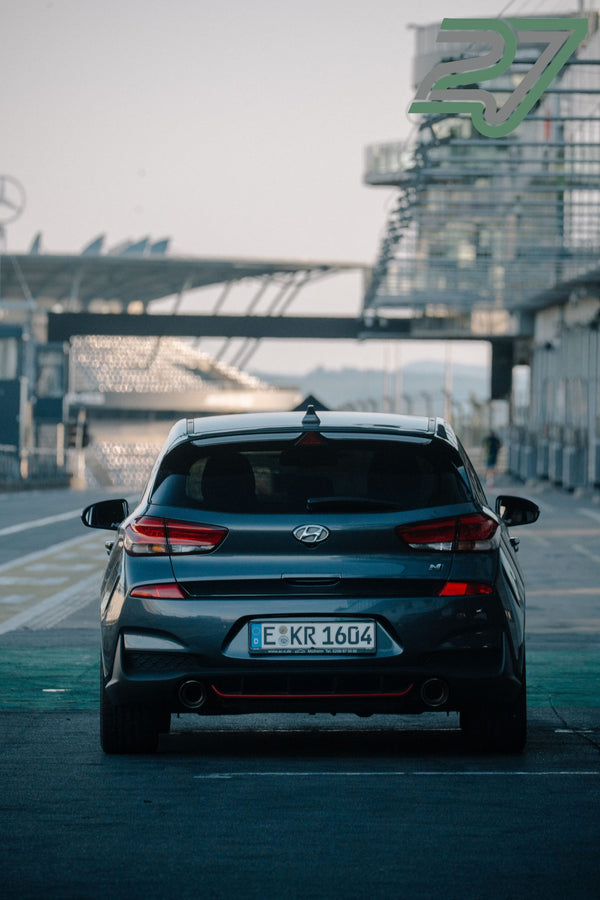 Dunkelgrauer Hyundai i30 N fährt mit Blick aufs Boxengebäude von der Kamera weg