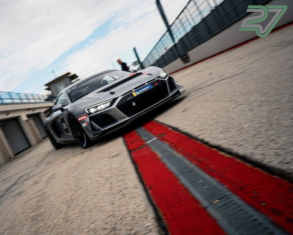 Grauer Audi R8 GT3 rollt in extremer Untersicht über den rot-weißen Curb Richtung Boxengasse