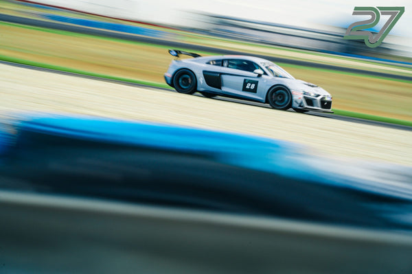 Silbergrauer Audi R8 mit Startnummer 28 rast im Profil an der Kamera vorbei, Bewegungsunschärfe