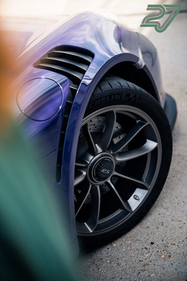 Nahaufnahme eines violett schimmernden Kotflügels mit Zentralverschluss-Felge und Michelin-Reifen