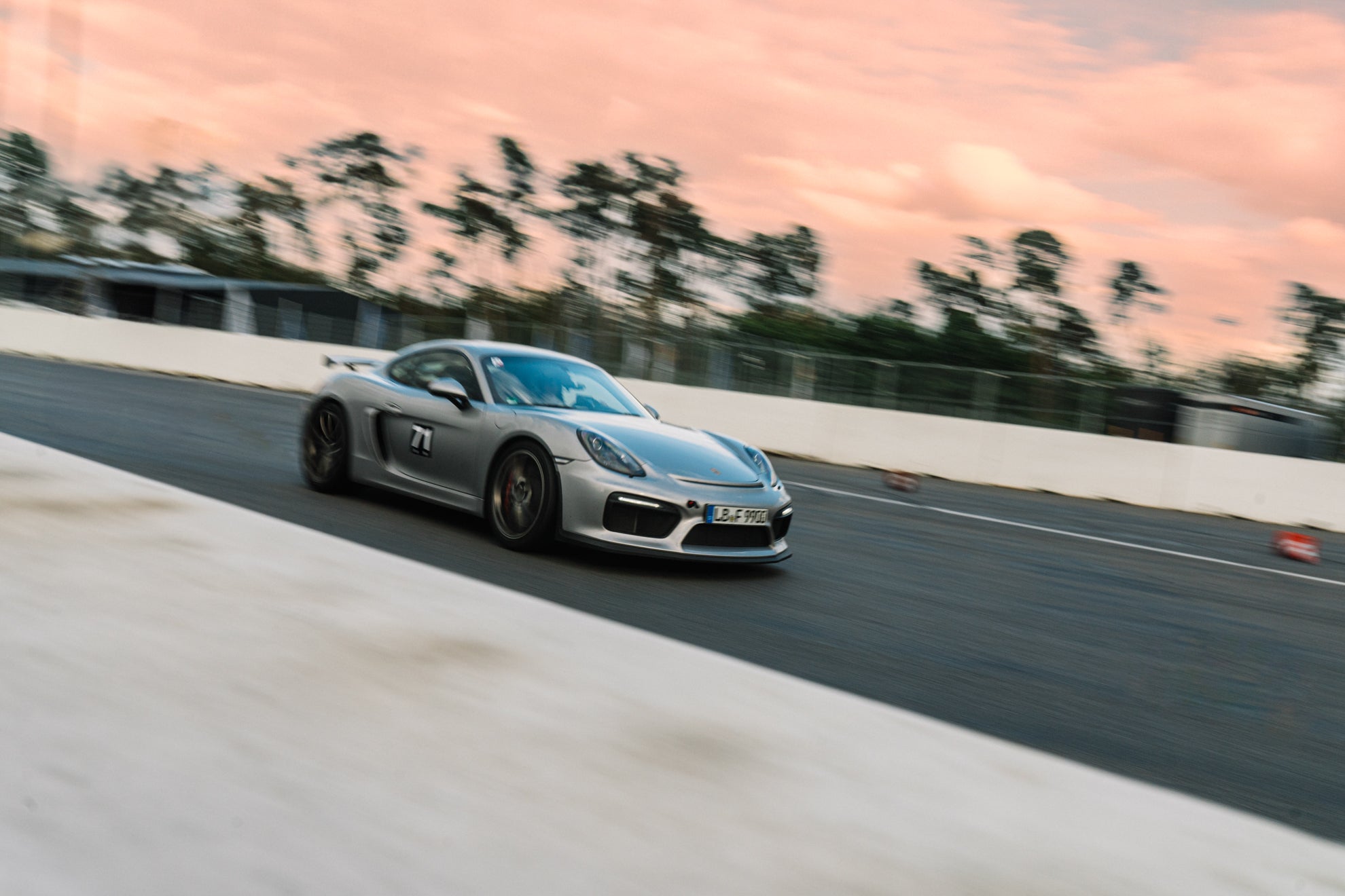 Grauer Porsche Cayman 981 GT4 bei einem Afterwork Trackday mit Sonnenuntergang.