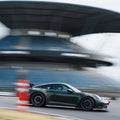 Porsche 992 GT3 in unkelgrün vor der Mercedes-Tribüne auf dem Nürburgring bei einem Afterwork Trackday.
