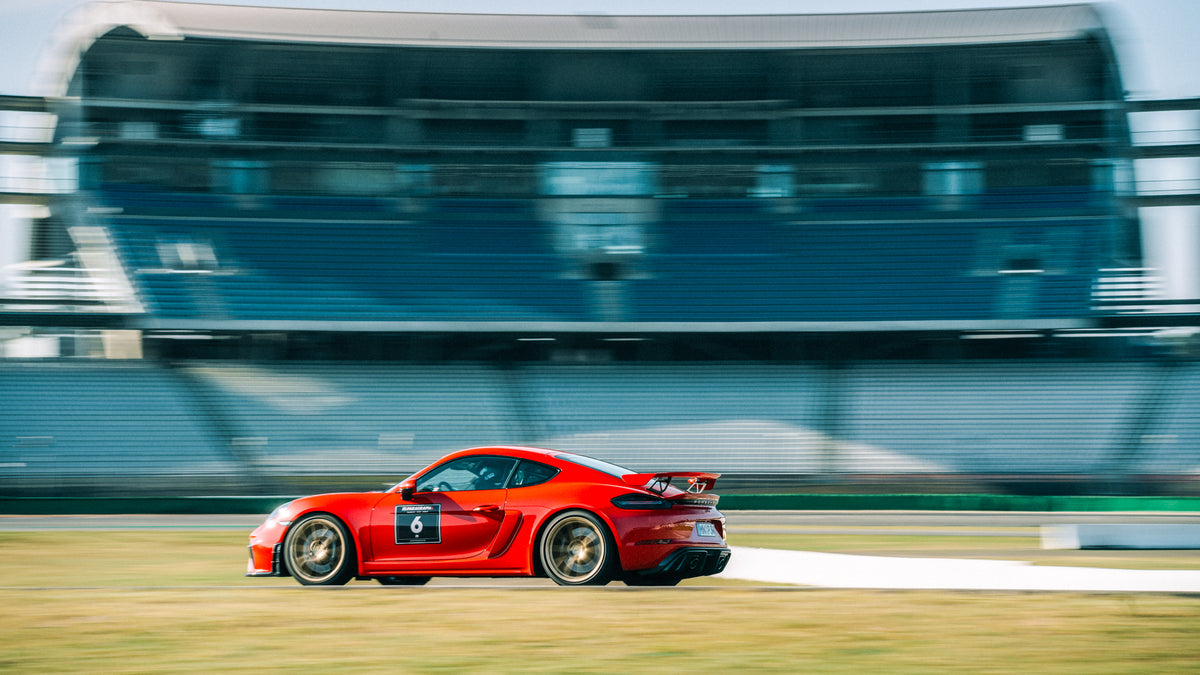 Red Porsche Cayman GT4 with gold wheels at an Afterwork Trackday