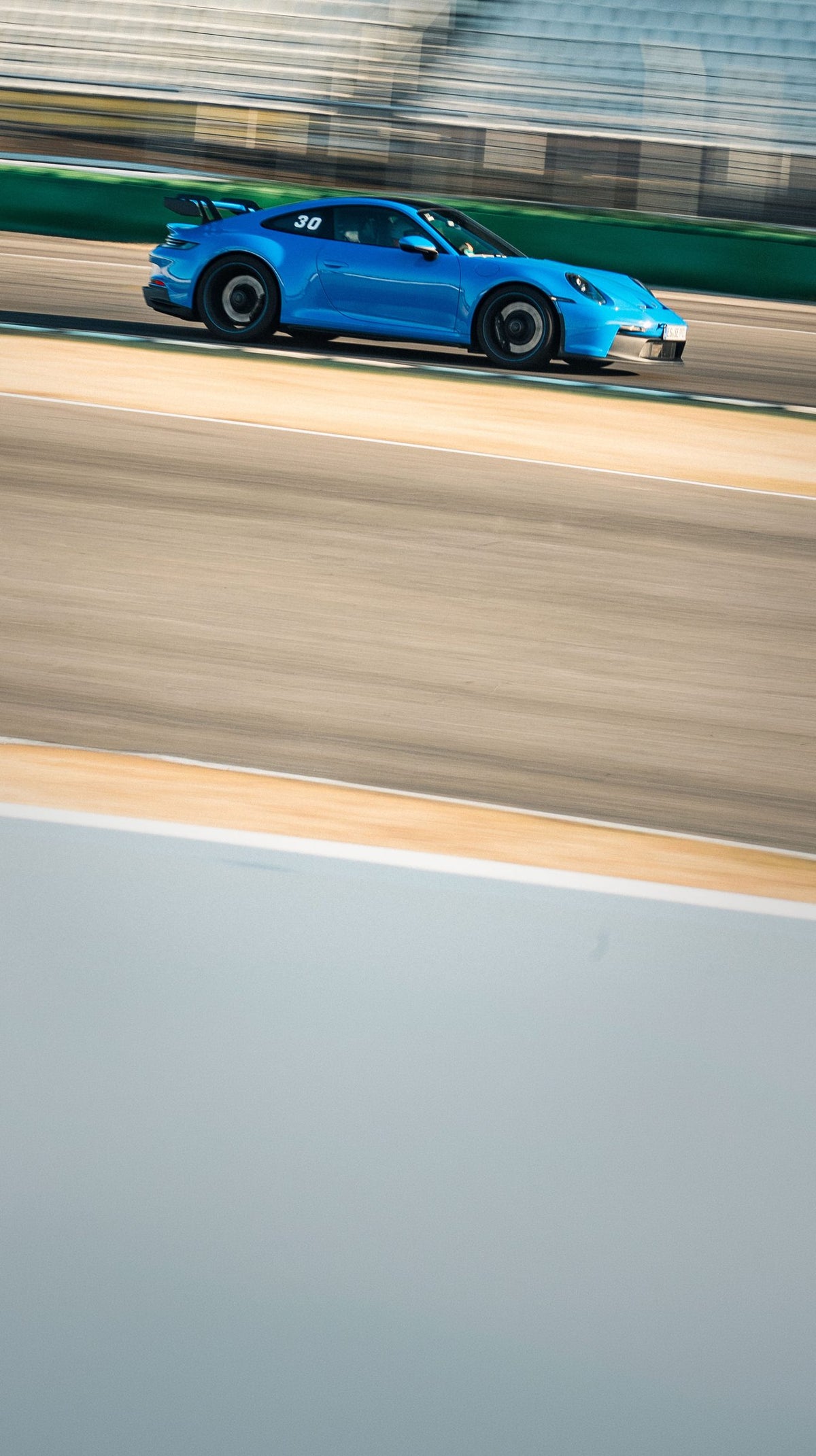 Row of parked Ferrari race cars in the pit lane, backlit, with a black Ferrari 488 Challenge at the front